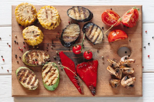 Verduras brillantes a la parrilla en tabla de cortar de madera —  Fotos de Stock