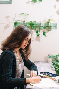 Genç kadın ressam dikkatle yan görünüm çizim