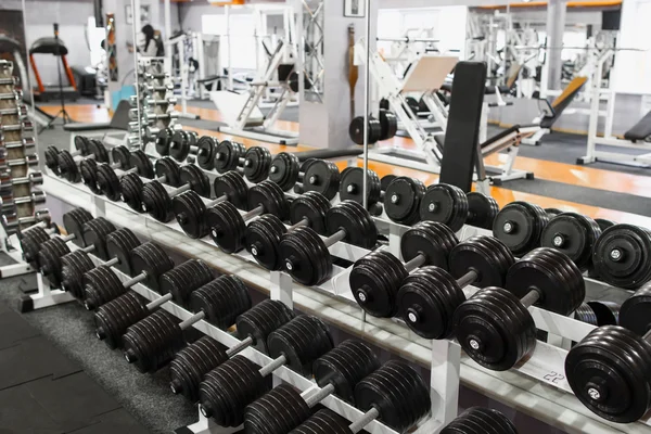 Rack with dumbbells at gym interior — Stock Photo, Image