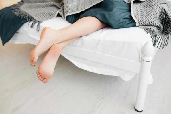 Kvinnliga nakna fötter ur sängen — Stockfoto