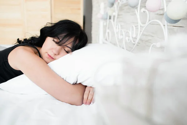 Sleeping brunette woman hugs pillow copyspace — Stock Photo, Image