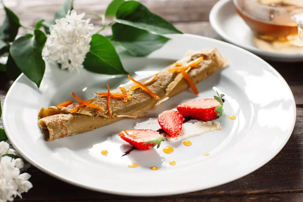 Panqueca enrolada com morango na placa branca — Fotografia de Stock