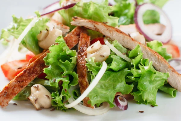 Куриный салат с грибами и луком крупным планом — стоковое фото