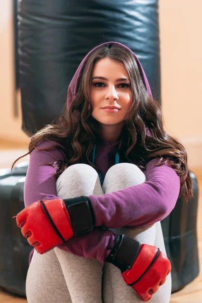 Retrato de mujer en guantes de boxeo, sosteniendo rodillas — Foto de Stock