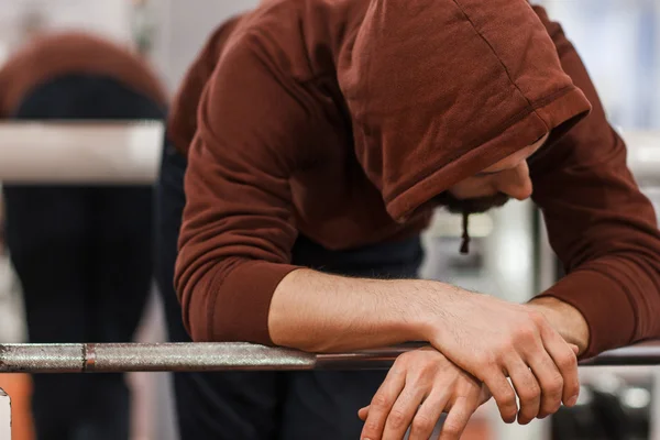 Moe man in sportsuit afhankelijk van barbell — Stockfoto