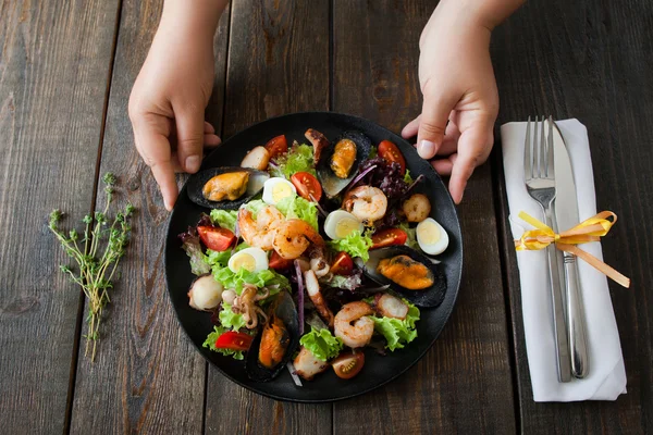 Serveur plat de service avec salade de fruits de mer chauds — Photo