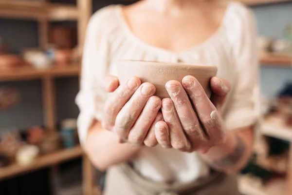 Женщина с грязными руками держит чашу, крупным планом, размытая — стоковое фото
