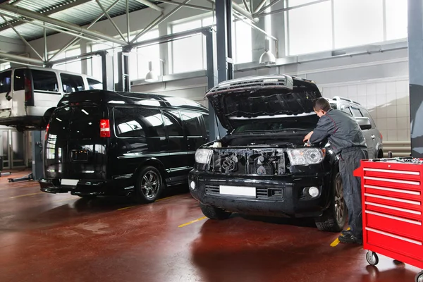 Mannelijke reparateur werken met motor in garage — Stockfoto