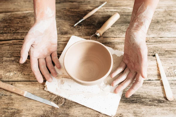 Manos de artesano con cerámica y herramientas en madera — Foto de Stock