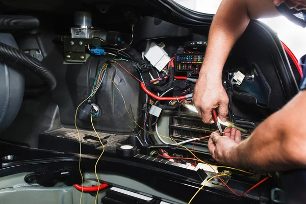 Eletricista trabalha com bloco elétrico no carro — Fotografia de Stock
