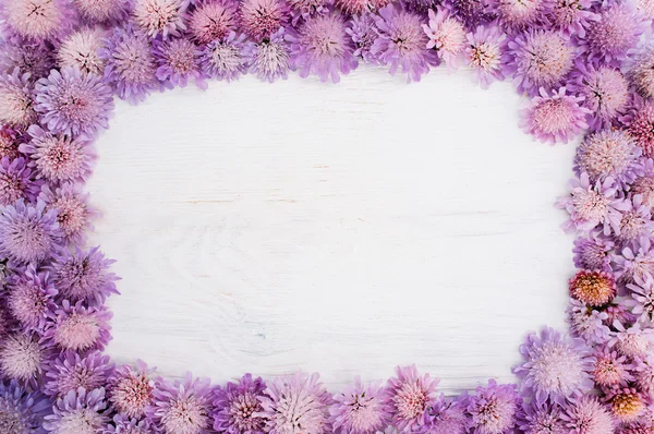 Frame of purple flowers on white, copyspace