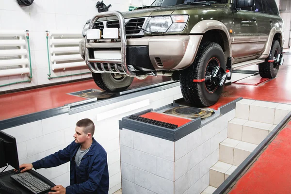 SUV passando por alinhamento de roda automática na garagem — Fotografia de Stock