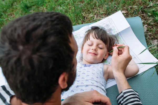 Pai fazendo cócegas filha com grama — Fotografia de Stock