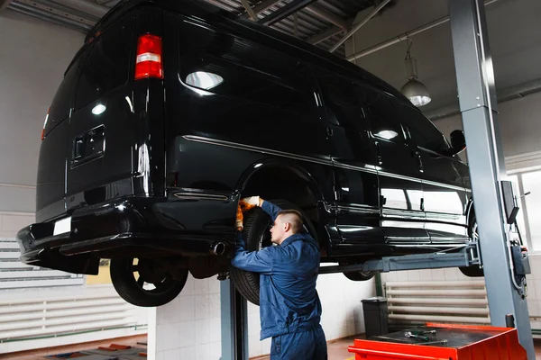 Zwarte minibus op reparatie in de garage — Stockfoto