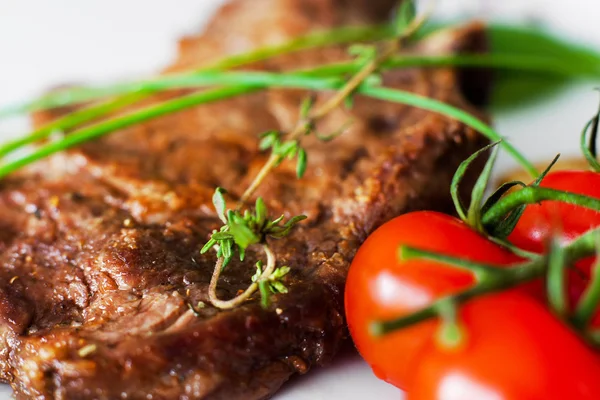 Filete a la parrilla con hierbas y primer plano de tomate cherry — Foto de Stock