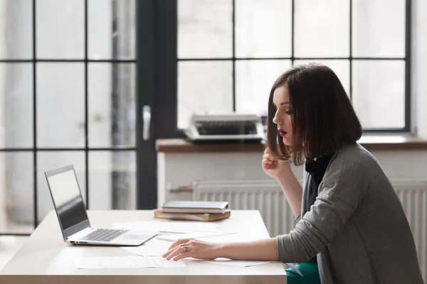 Atractiva mujer de negocios leyendo papeleo — Foto de Stock