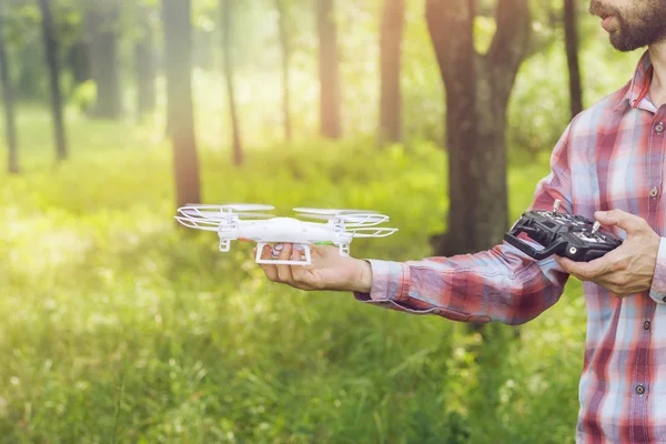 Oigenkännlig mans kör quadrocopter i skogen — Stockfoto