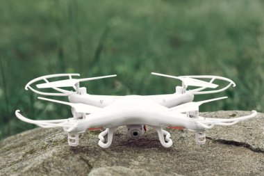 White quadrocopter on stone, drone, close-up