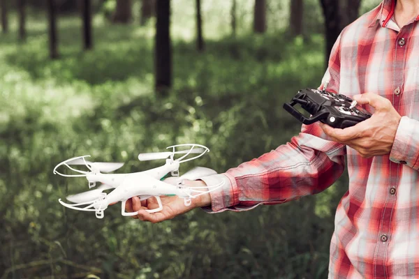 Homem irreconhecível correndo drone na floresta — Fotografia de Stock