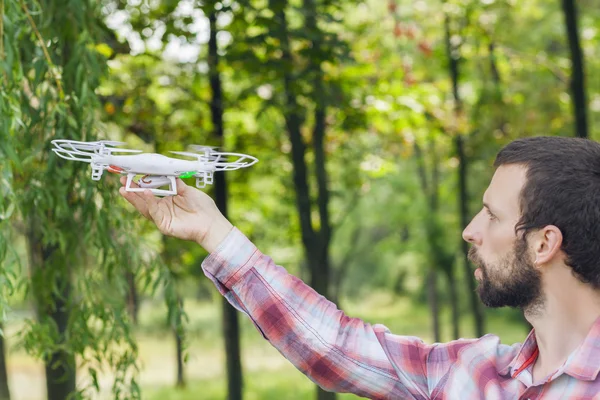 Homem correndo quadrocopter na floresta — Fotografia de Stock