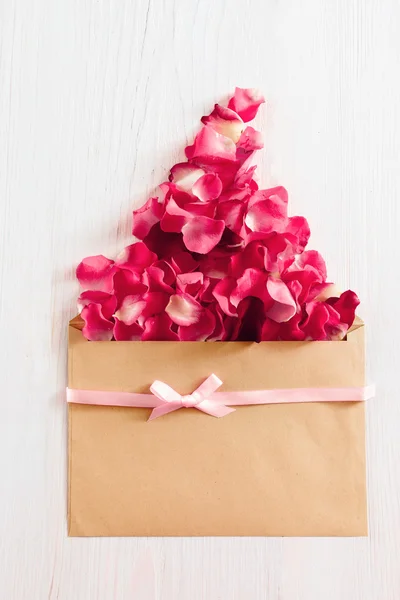 Fundo floral com envelope e pétalas de rosa — Fotografia de Stock