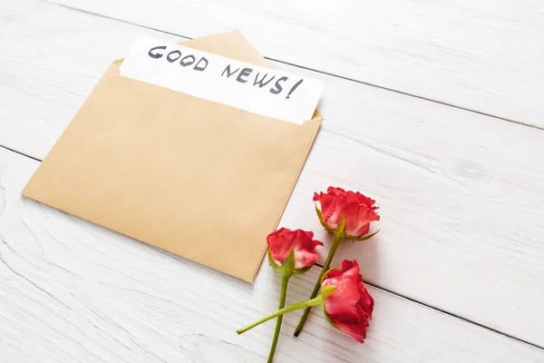 Boa notícia nota em envelope marrom com flores — Fotografia de Stock