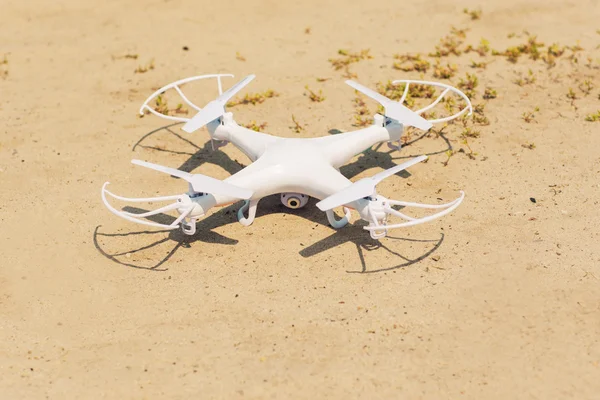 Quadrocopter branco na areia, close-up — Fotografia de Stock