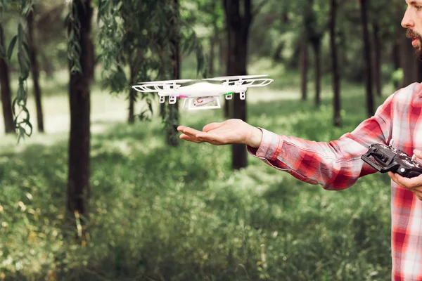 Homem irreconhecível correndo quadrocopter na floresta — Fotografia de Stock