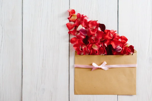 Envelope marrom com pétalas de flor vermelha, espaço de cópia — Fotografia de Stock