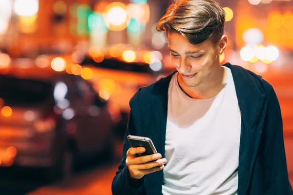 Joven guapo usando smartphone en la ciudad —  Fotos de Stock