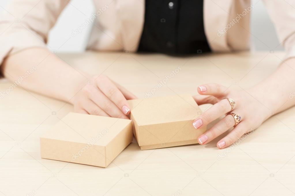 Woman holding two carton boxes on table