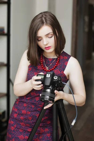 Vacker kvinna tittar på foton på hennes kamera — Stockfoto