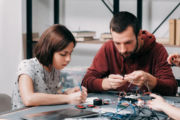 Male and female engineers constructing diy model — Stock Photo, Image