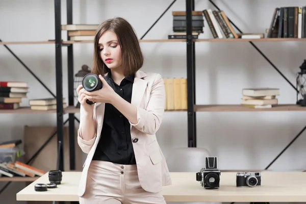 Vrouwelijke fotograaf kiezen camera voor werk — Stockfoto