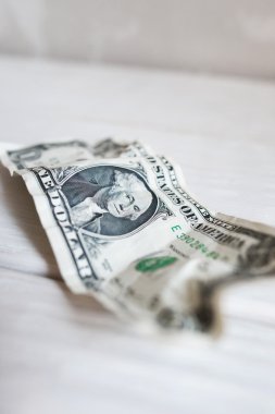 Worn crumpled one dollar bill, blurry, close-up