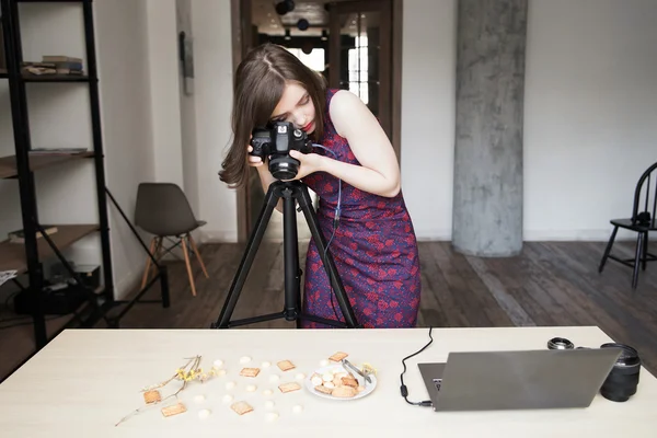 Woman photographing cookies set in studio — Stockfoto