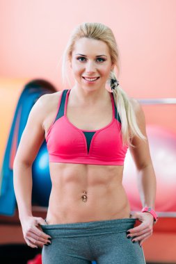 Pembe portre gülümseyen güzel fitness sarışın