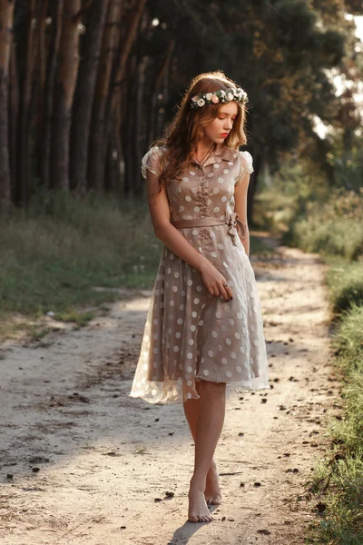 Young woman in wreath walking in forest barefoot — 图库照片