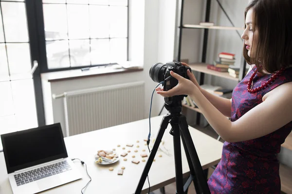Kvinnlig fotograf tuning hennes kamera på studio — Stockfoto