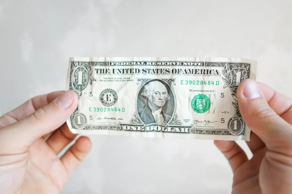 Банкнота в долларах США в мужских руках — стоковое фото