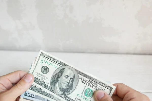 Мужская рука держит банкноты по сто долларов. — стоковое фото