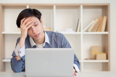 Yorgun öğrenci mesafesi. Dalgın Asyalı adam öğreniyor.