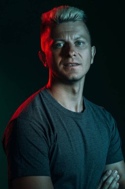 Atletik adam neon ışıklı, kendinden emin, karanlık.