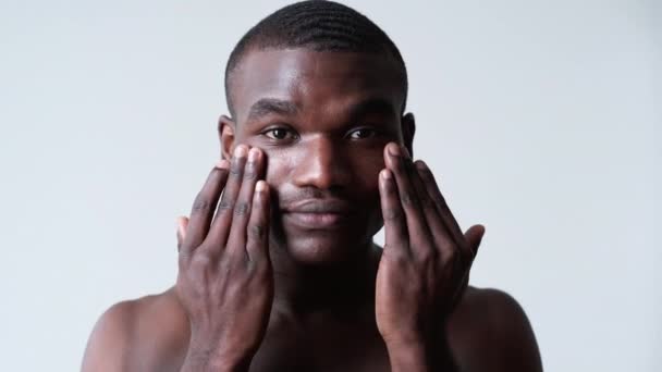 Man huidverzorging gezichtsbehandeling afrikaanse man crème — Stockvideo