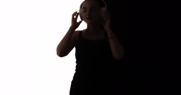 女性のシルエットワイヤレスヘッドフォンの音を踊る — ストック動画