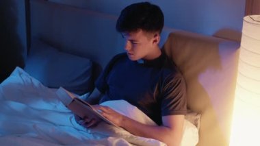 Gece geç saatlere kadar ders çalışıp kitap okuyan adam.