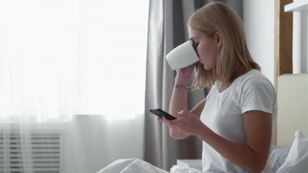 Mattina routine caffè letto donna telefono luce solare — Video Stock