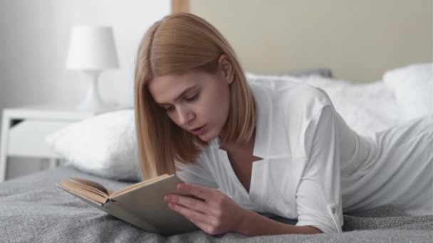 Утренняя книга чтение хобби расслабленной женщины уютная кровать — стоковое видео