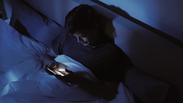 Пізно онлайн безсонна ніч нудьгує чоловік телефонне ліжко — стокове відео