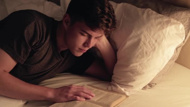 Lefekvés szabadidő olvasás hobbi fáradt fickó könyv késő — Stock videók